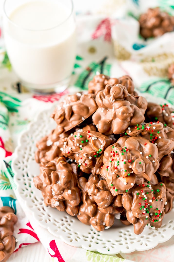 Crockpot Candy is loaded with peanuts, almond bark, and lots of chocolate and super easy to make in the slow cooker! Topped with some festive sprinkles, this pop-in-your-mouth treat is perfect for sharing during the holiday season.