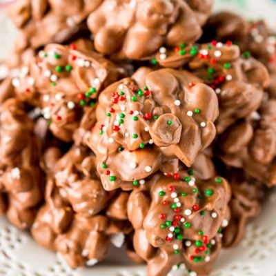 Crockpot Candy is loaded with peanuts, almond bark, and lots of chocolate and super easy to make in the slow cooker! Topped with some festive sprinkles, this pop-in-your-mouth treat is perfect for sharing during the holiday season.