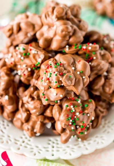 Crockpot Candy is loaded with peanuts, almond bark, and lots of chocolate and super easy to make in the slow cooker! Topped with some festive sprinkles, this pop-in-your-mouth treat is perfect for sharing during the holiday season.