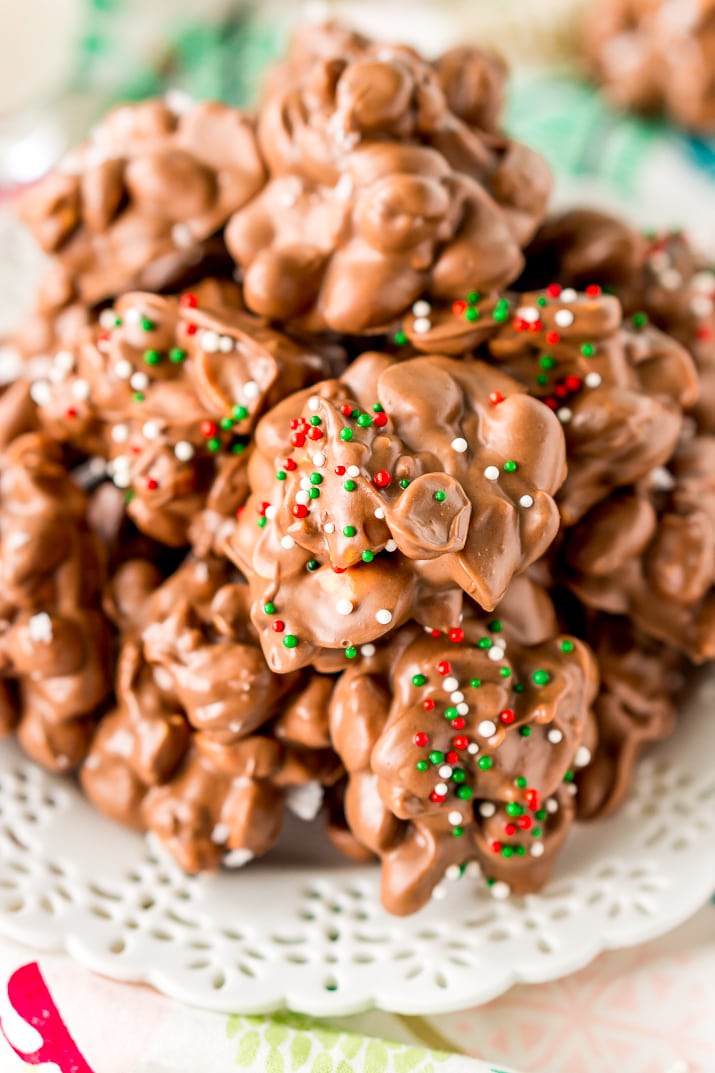 Crockpot Candy is loaded with peanuts, almond bark, and lots of chocolate and super easy to make in the slow cooker! Topped with some festive sprinkles, this pop-in-your-mouth treat is perfect for sharing during the holiday season.