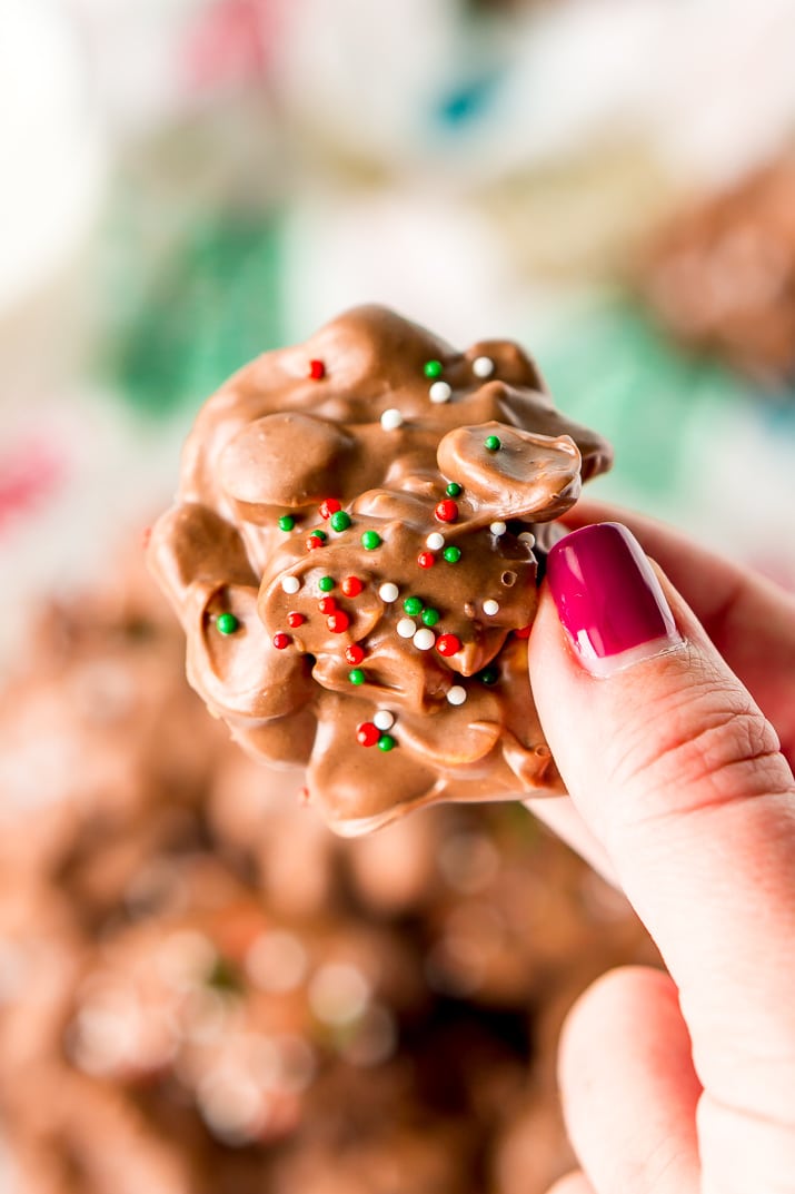 Crockpot Candy is loaded with peanuts, almond bark, and lots of chocolate and super easy to make in the slow cooker! Topped with some festive sprinkles, this pop-in-your-mouth treat is perfect for sharing during the holiday season.