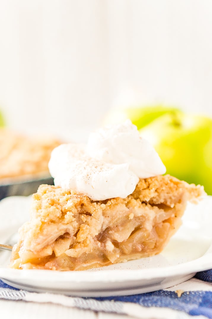 A slice of Dutch Apple Pie on a white plate.