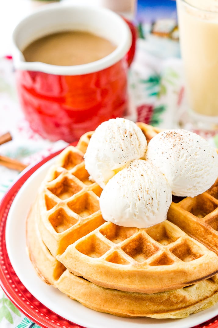 Eggnog Waffles are crisp and golden on the outside and fluffy on the inside, topped with whipped cream and spiced vanilla syrup!