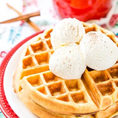 Eggnog Waffles are crisp and golden on the outside and fluffy on the inside, topped with whipped cream and spiced vanilla syrup!
