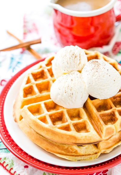 Eggnog Waffles are crisp and golden on the outside and fluffy on the inside, topped with whipped cream and spiced vanilla syrup!