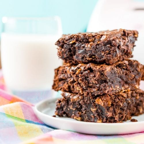 Three Lactation Brownies stacked on a plate in front of a glass of milk