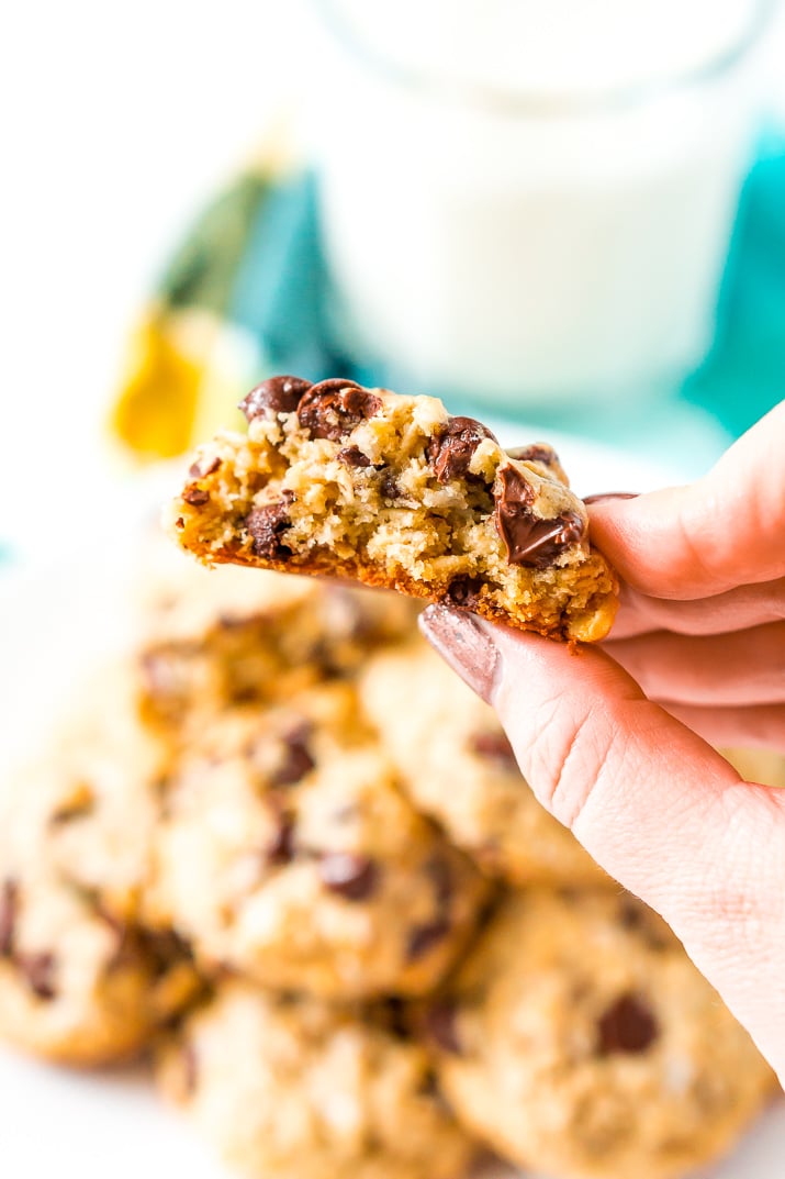 Woman's hand holding a Lactation Cookie that has had a bite taken out of it.