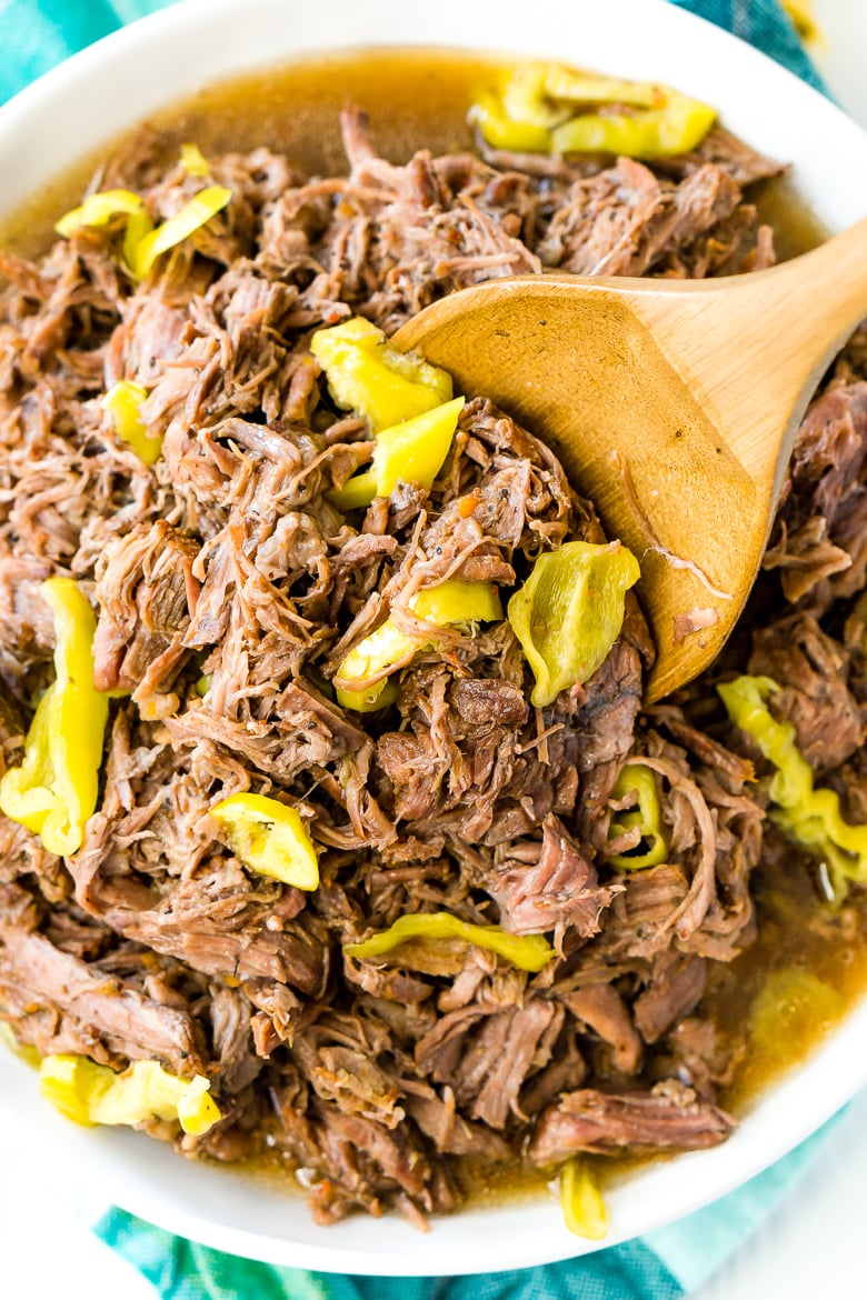 Italian Beef in white bowl with wooden spoon