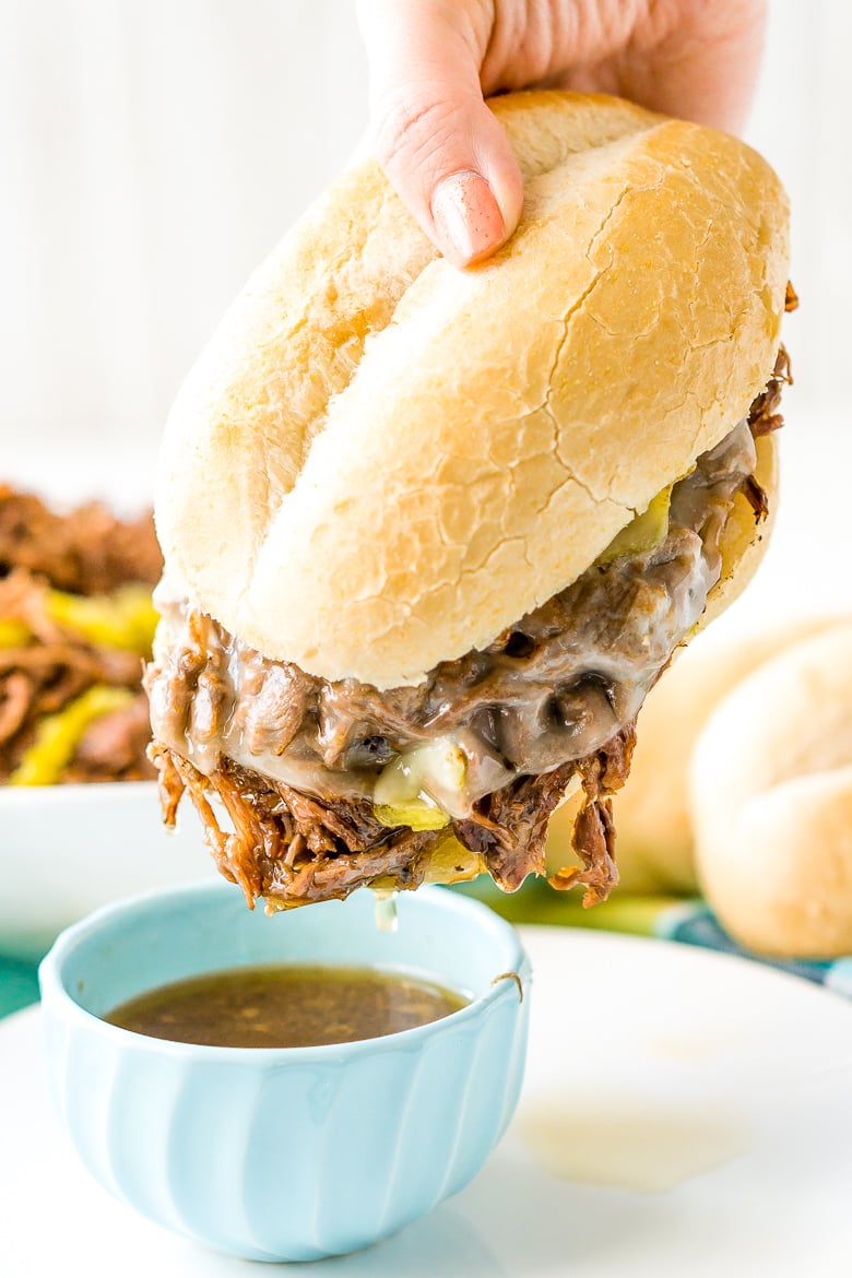 Italian beef Sandwich being dipped in au jou