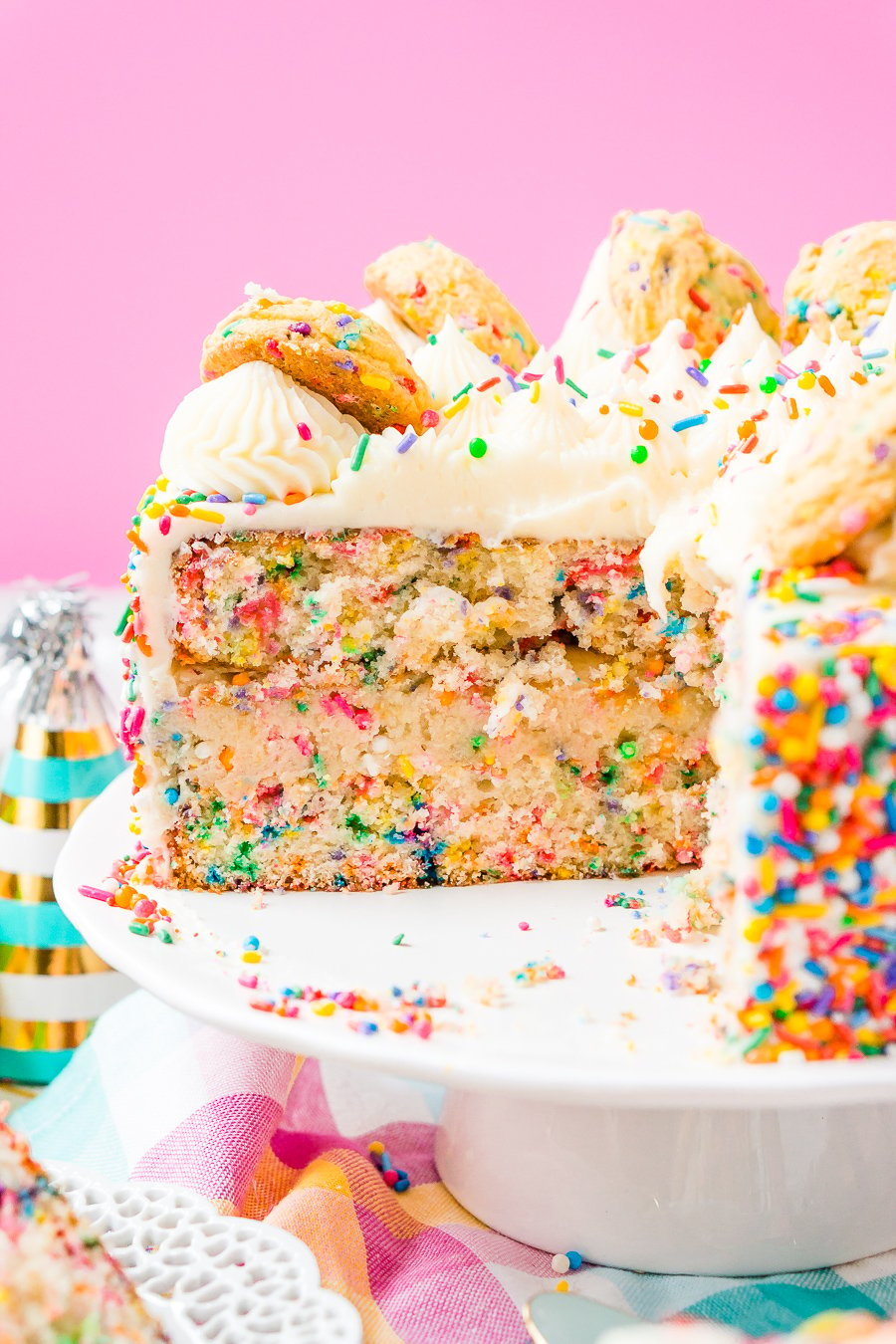 This Funfetti Sugar Cookie Dough Cake is an over the top cake made with two layers of white almond cake loaded with sprinkles and a layer of edible sugar cookie dough, then topped with classic vanilla buttercream!