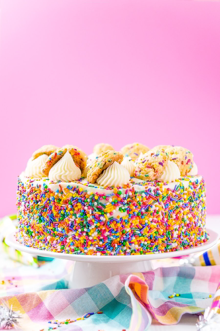 This Funfetti Sugar Cookie Dough Cake is an over the top cake made with two layers of white almond cake loaded with sprinkles and a layer of edible sugar cookie dough, then topped with classic vanilla buttercream!