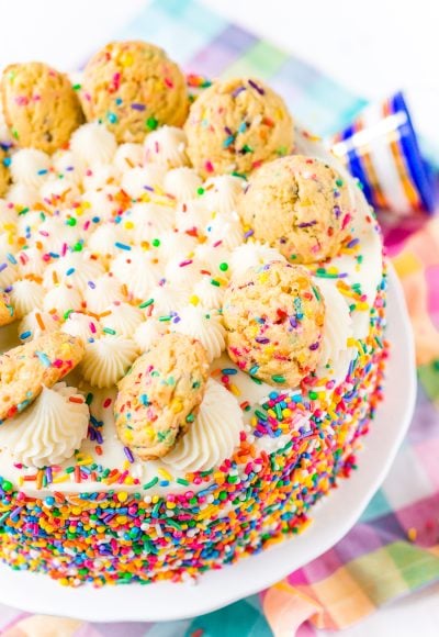 This Funfetti Sugar Cookie Dough Cake is an over the top cake made with two layers of white almond cake loaded with sprinkles and a layer of edible sugar cookie dough, then topped with classic vanilla buttercream!