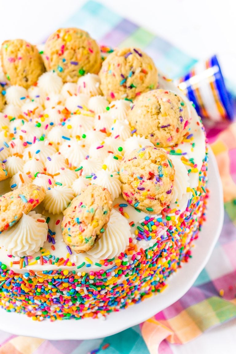 This Funfetti Sugar Cookie Dough Cake is an over the top cake made with two layers of white almond cake loaded with sprinkles and a layer of edible sugar cookie dough, then topped with classic vanilla buttercream!