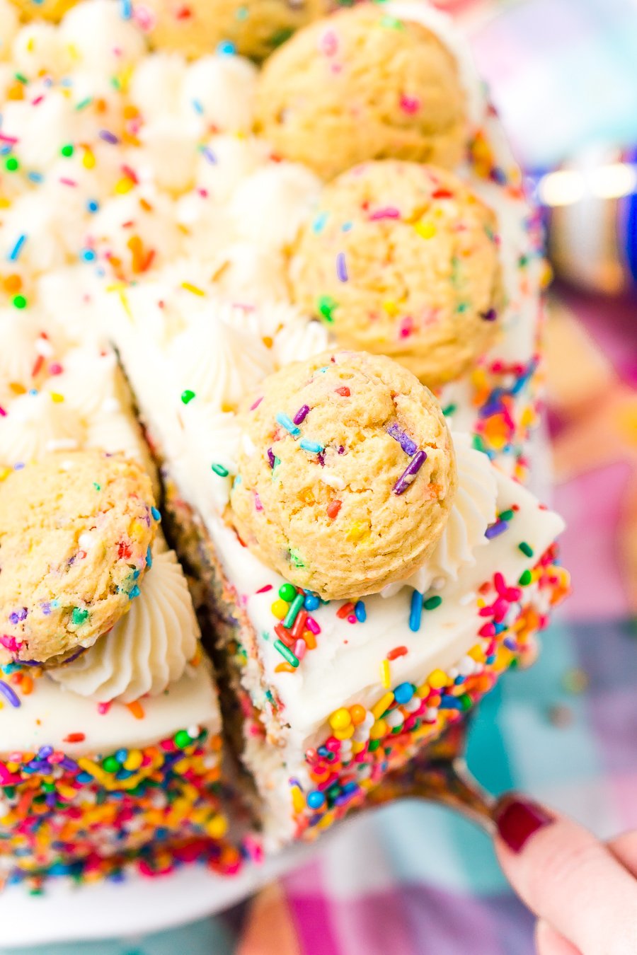 This Funfetti Sugar Cookie Dough cake is an over the top cake made with two layers of white almond cake loaded with sprinkles and a layer of edible sugar cookie dough, then topped with classic vanilla buttercream!