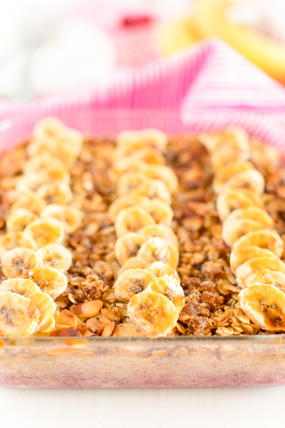 Baking dish with Raspberry Almond Baked Oatmeal in it topped with caramelized slices of bananas.