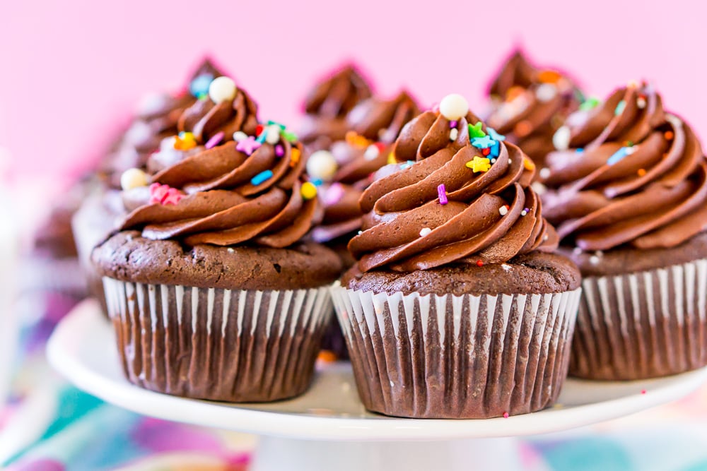 Chocolate Cupcakes with Chocolate buttercream Frosting on white cake stand with pink background