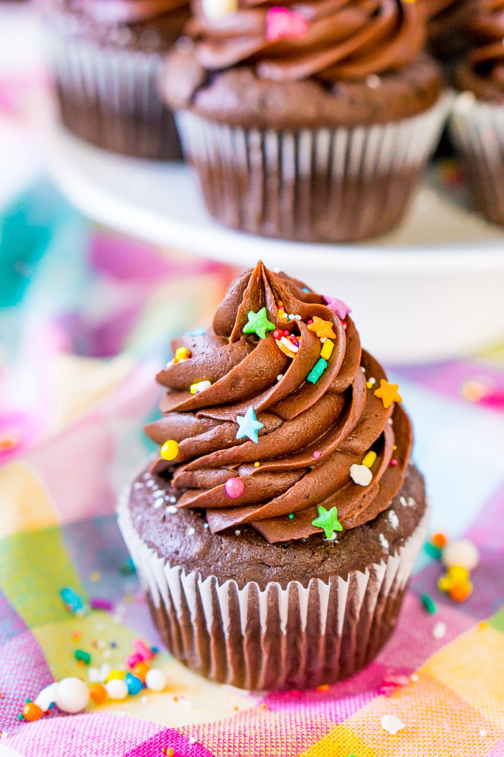 Chocolate Cupcake with Chocolate Buttercream Frosting on colorful napkin with colorful sprinkles