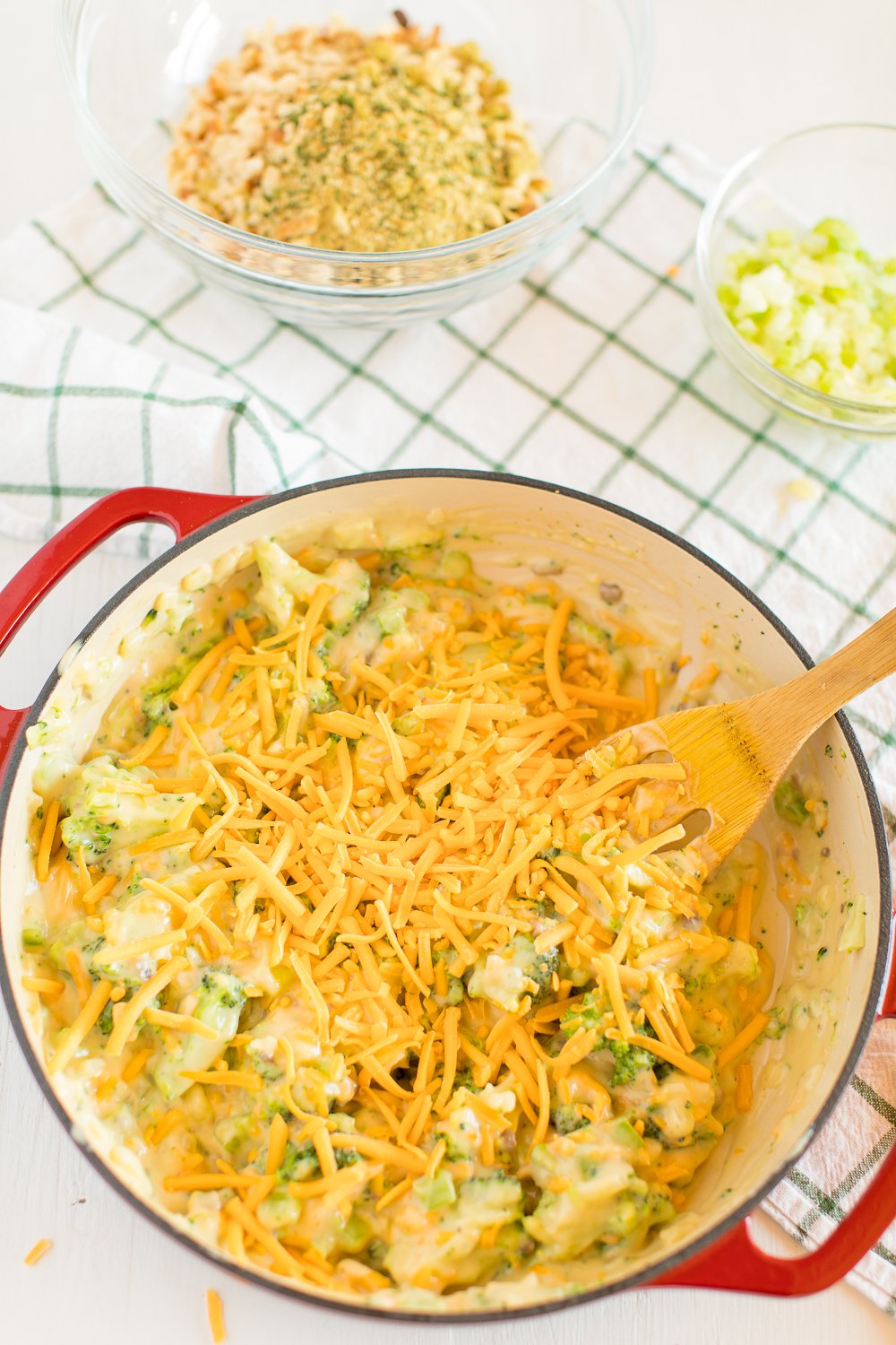 Pot with ingredients for Broccoli Cheese Casserole and mixing spoon in it.