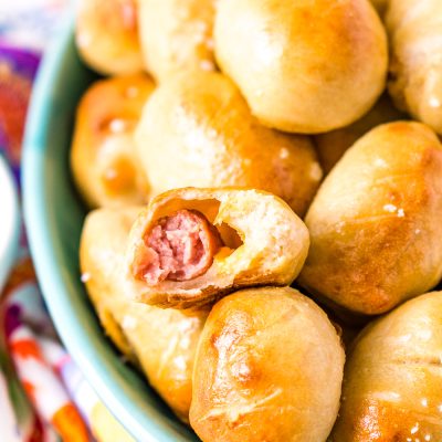 These Pretzel Pigs In A Blanket take two of your favorite party foods and combine them into one! Mini sausages and cheddar cheese wrapped in dough and baked to perfection!