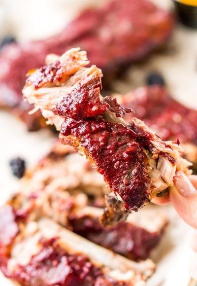 These Crock Pot Ribs are juicy, tender, and full of flavor! Easy to make and messy to eat, these baby back ribs are smothered in a sweet blackberry barbecue sauce! Perfect for game days!