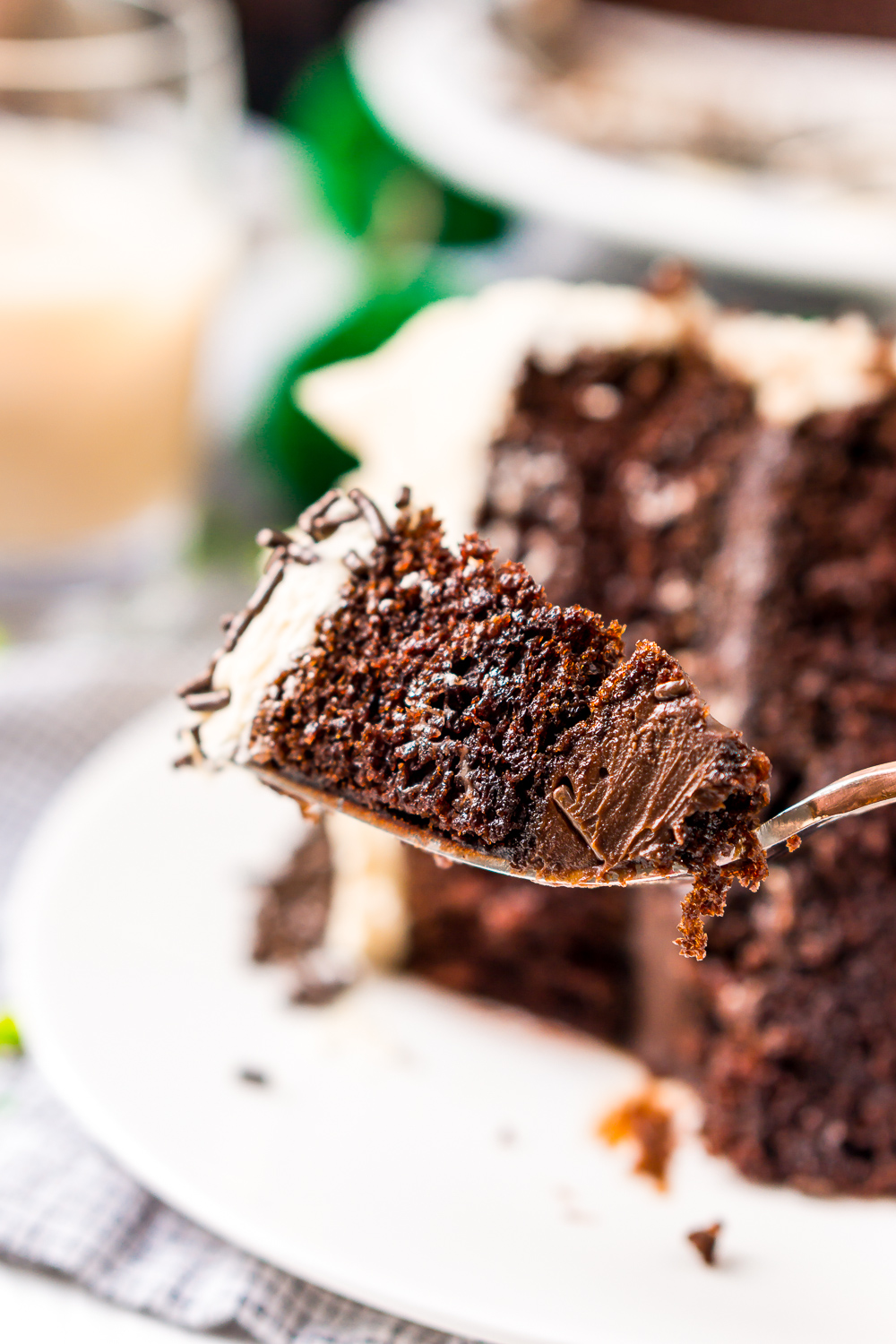 Bite of Chocolate Guinness Cake on a fork with slice of cake in the background.