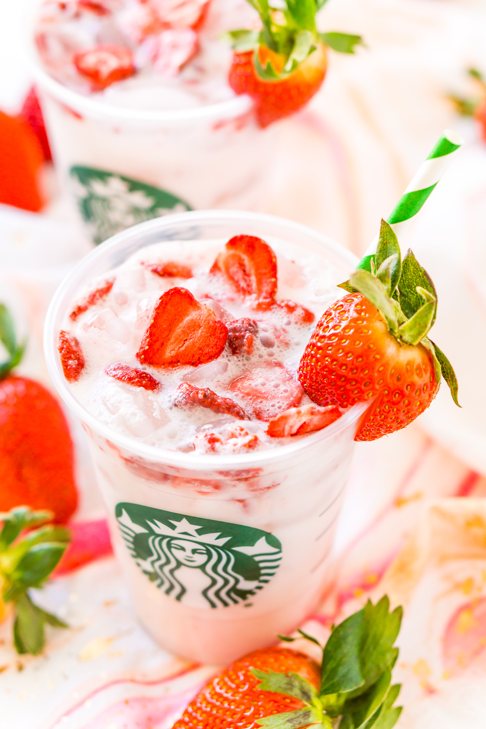 Cette boisson rose Copycat Starbucks est une recette moins chère et tout aussi délicieuse pour préparer votre boisson Starbucks fruitée préférée directement à la maison avec du thé aux baies d'açai, du lait de coco, du jus de raisin blanc, du sirop simple et des fraises lyophilisées !