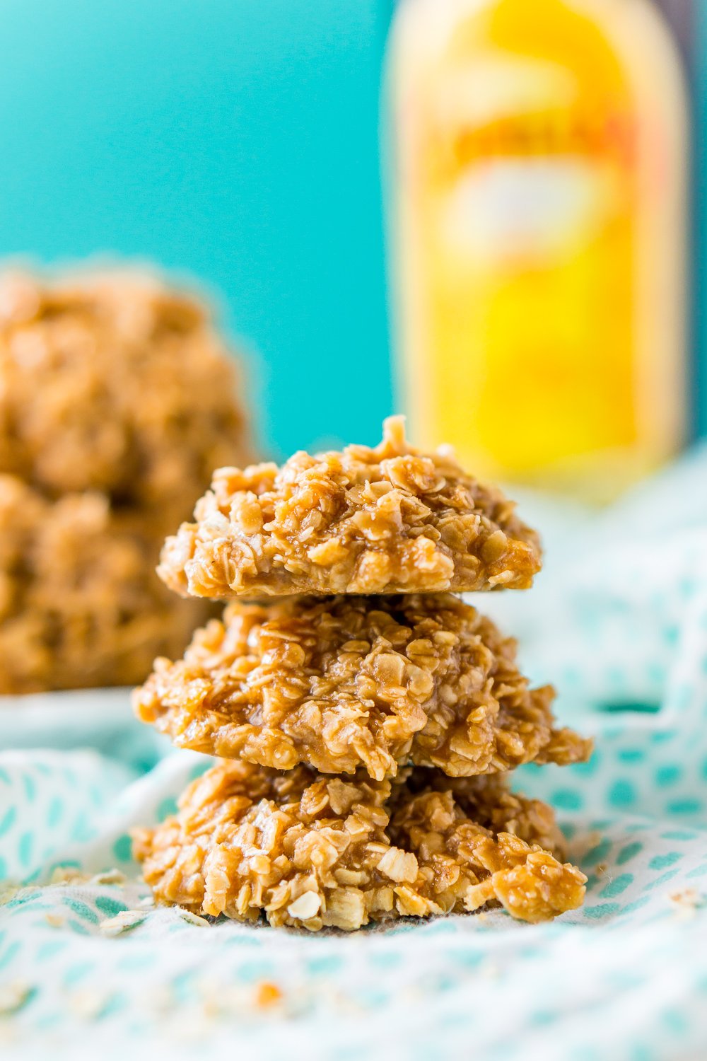 Three Kahlua No Bake Cookies stacked on top of each other with Kahlua bottle in background