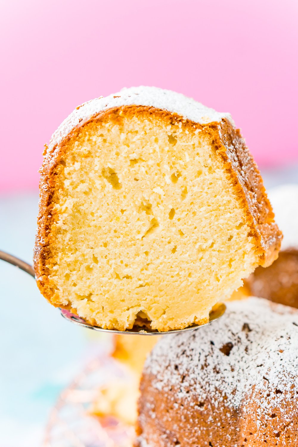 Slice of Cream Cheese Pound Cake on a cake server being pulled from cake.