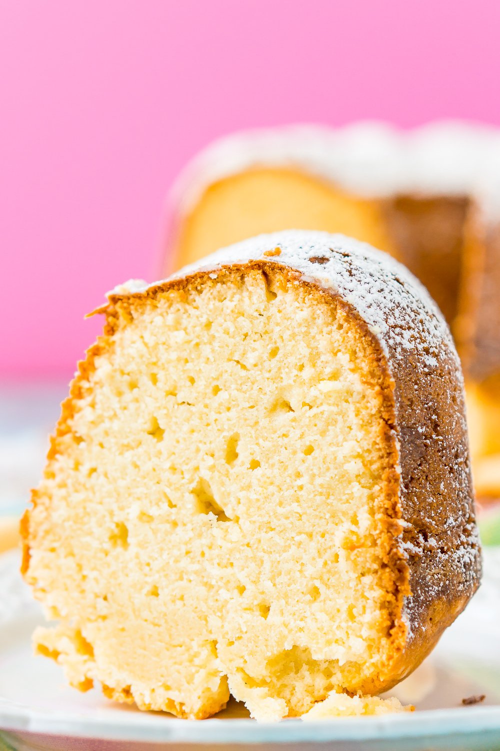 Close up photo of a slice of cream cheese pound cake on a white plate.