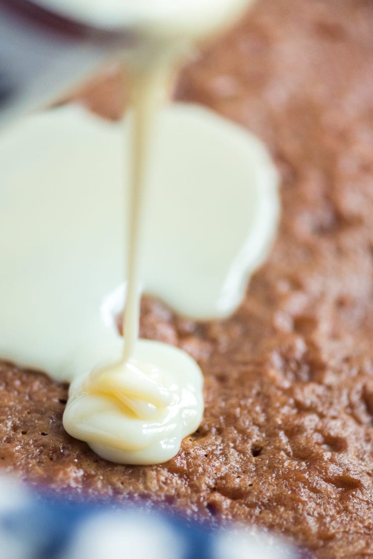 Pouring sweetened condensed milk over carrot cake.