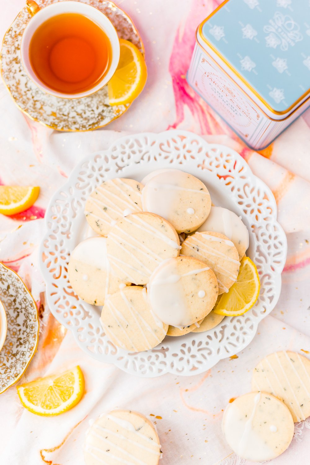 White plate filled with Earl Grey Shortbread Cookies with cups of tea and lemon slices.