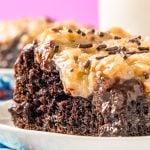 This German Chocolate Poke Cake takes the classic dessert recipe to a whole new level with a tender chocolate cake soaked in sweetened condensed milk and topped with a rich chocolate ganache and sweet coconut pecan frosting!