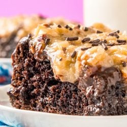 This German Chocolate Poke Cake takes the classic dessert recipe to a whole new level with a tender chocolate cake soaked in sweetened condensed milk and topped with a rich chocolate ganache and sweet coconut pecan frosting!