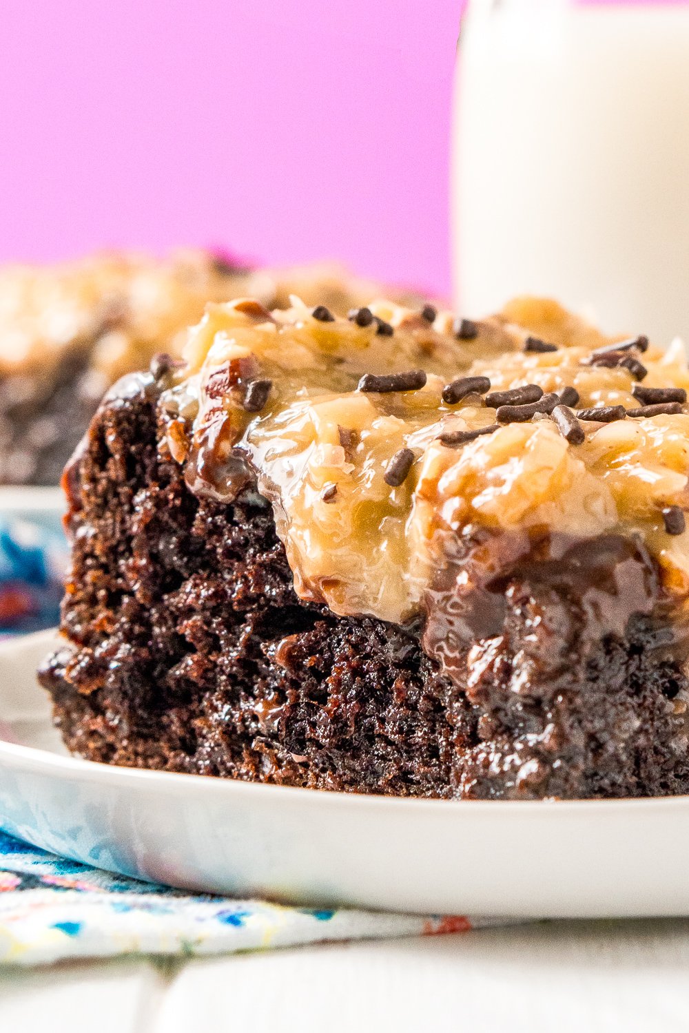 This German Chocolate Poke Cake takes the classic dessert recipe to a whole new level with a tender chocolate cake soaked in sweetened condensed milk and topped with a rich chocolate ganache and sweet coconut pecan frosting!