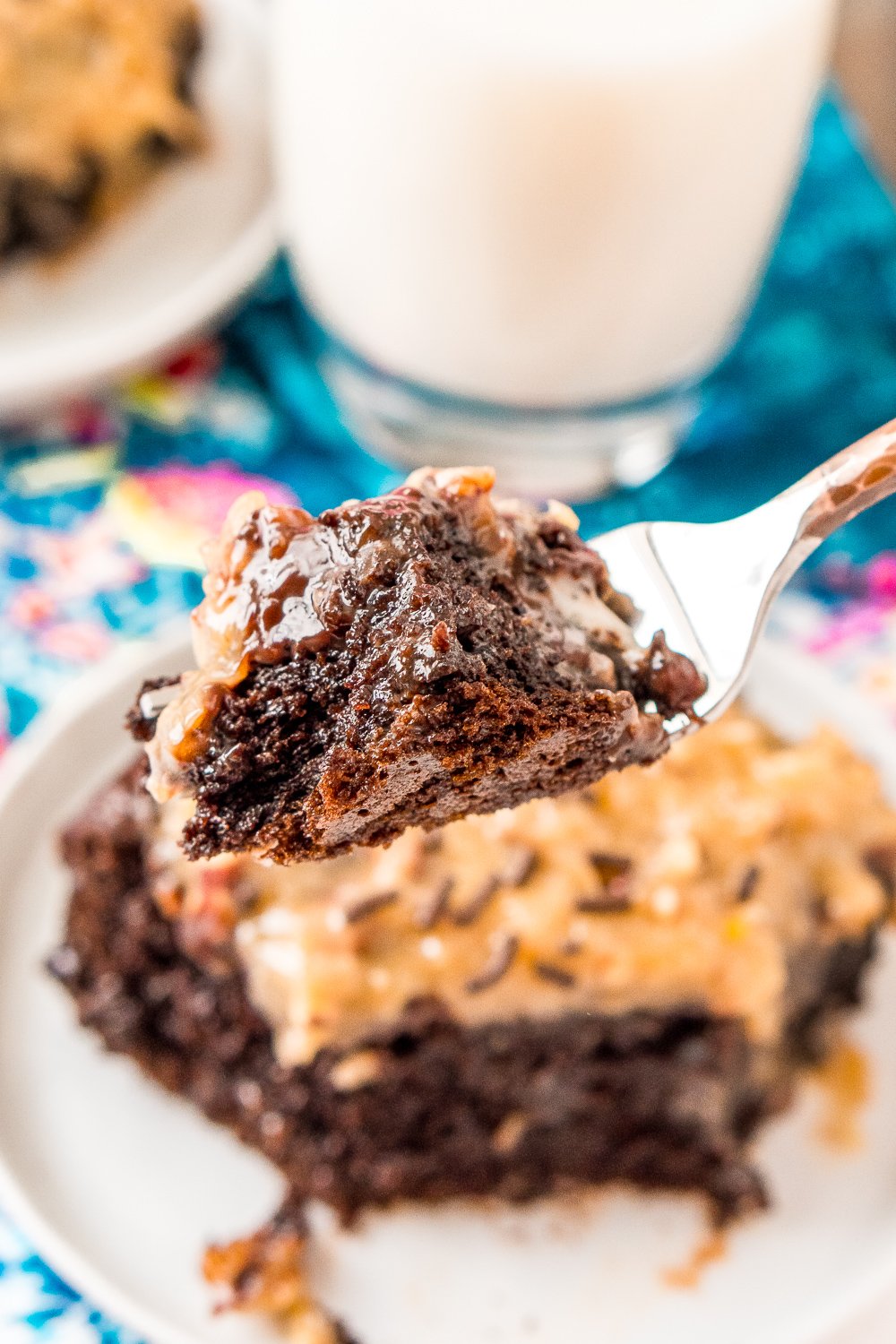 Fork with a bite of German Chocolate Poke Cake on it.