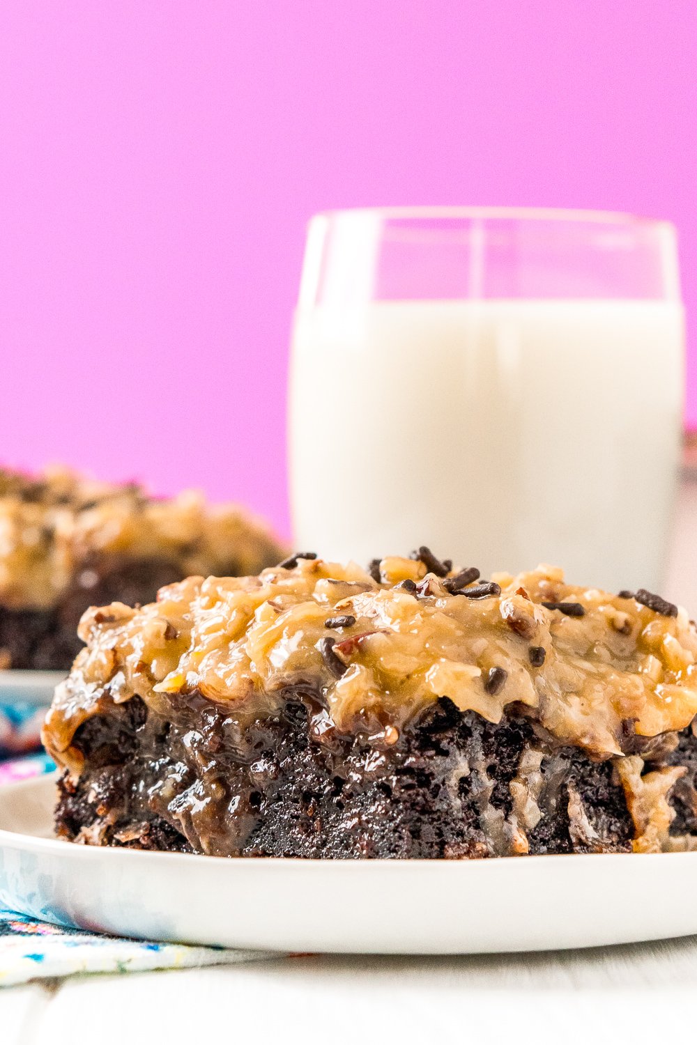 This German Chocolate Poke Cake takes the classic dessert recipe to a whole new level with a tender chocolate cake soaked in sweetened condensed milk and topped with a rich chocolate ganache and sweet coconut pecan frosting!