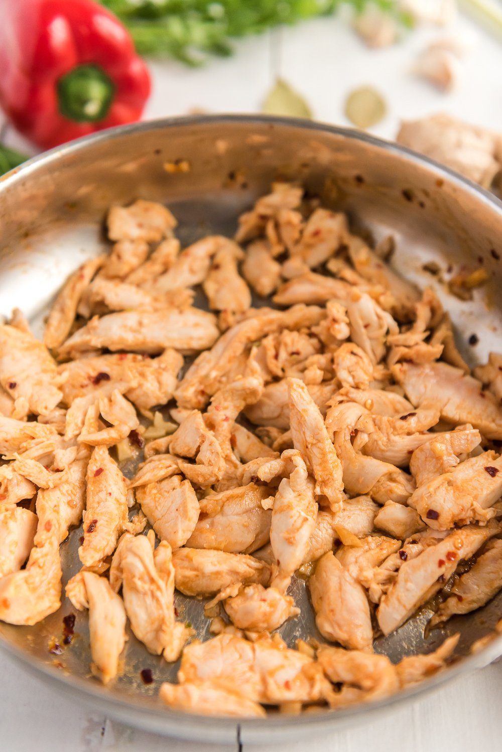 Seared chicken for chicken coconut soup in a skillet.