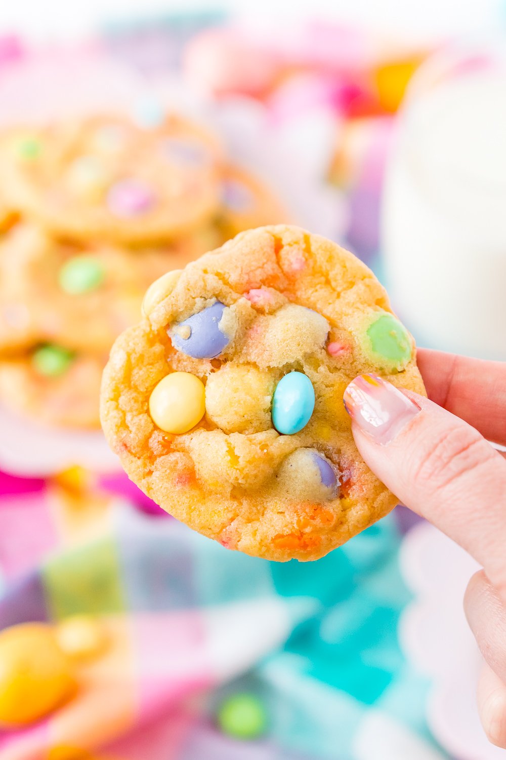 Woman's hand holding an M&Ms cookie.