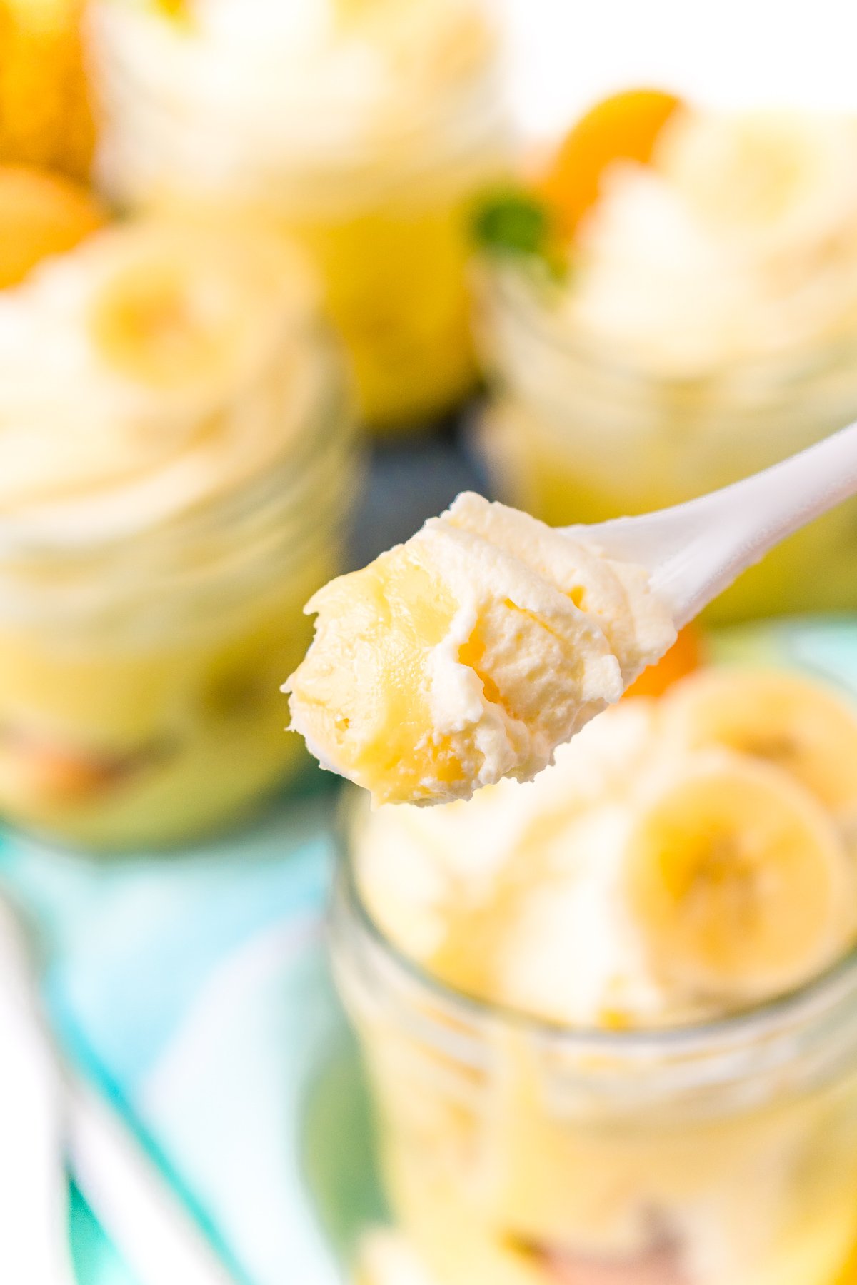 Spoonful of banana pudding with jars of pudding in the background.