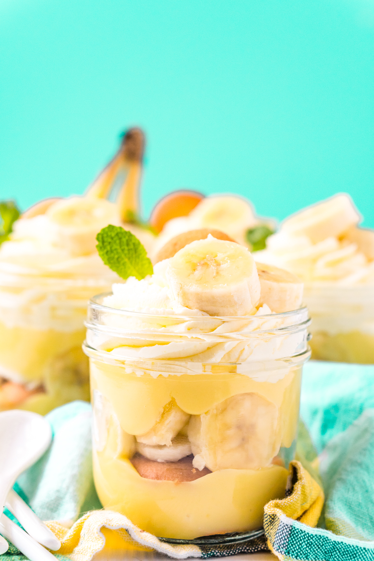 Jars of banana pudding on a blue napkin.