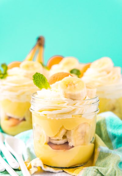 Jars of banana pudding ready to be served on a blue napkin.