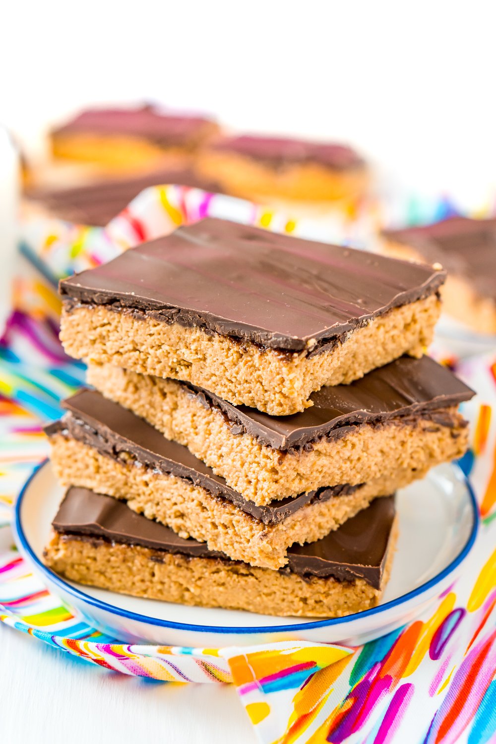 Stack of 4 peanut butter bars on a small white plate.