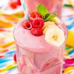 Raspberry banana smoothies on a colorful napkin.