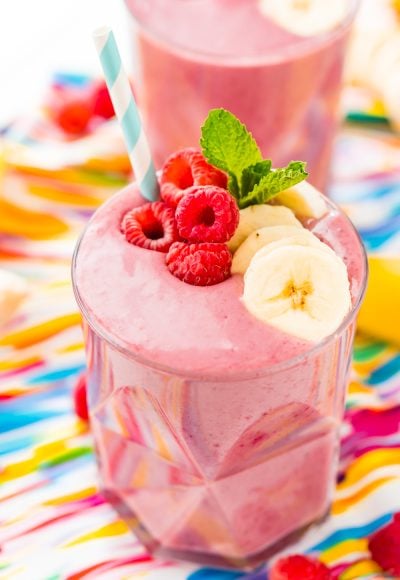 Raspberry banana smoothies on a colorful napkin.