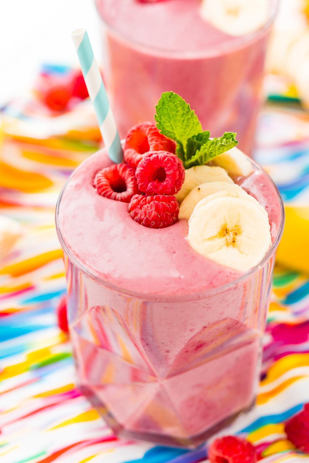 Raspberry banana smoothies on a colorful napkin.