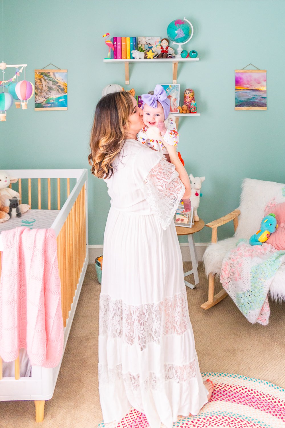 Woman holding baby girl in travel inspired nursery