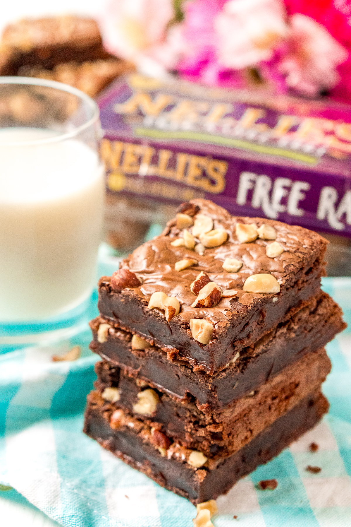 Stack of hazelnut brownies with a glass of milk in the background.