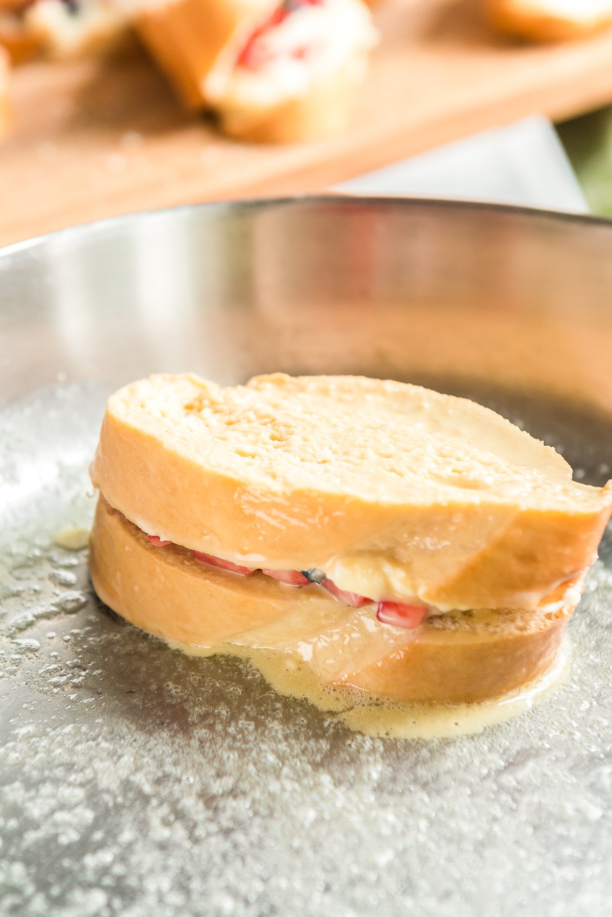 French toast cooking in a stainless steel skillet.