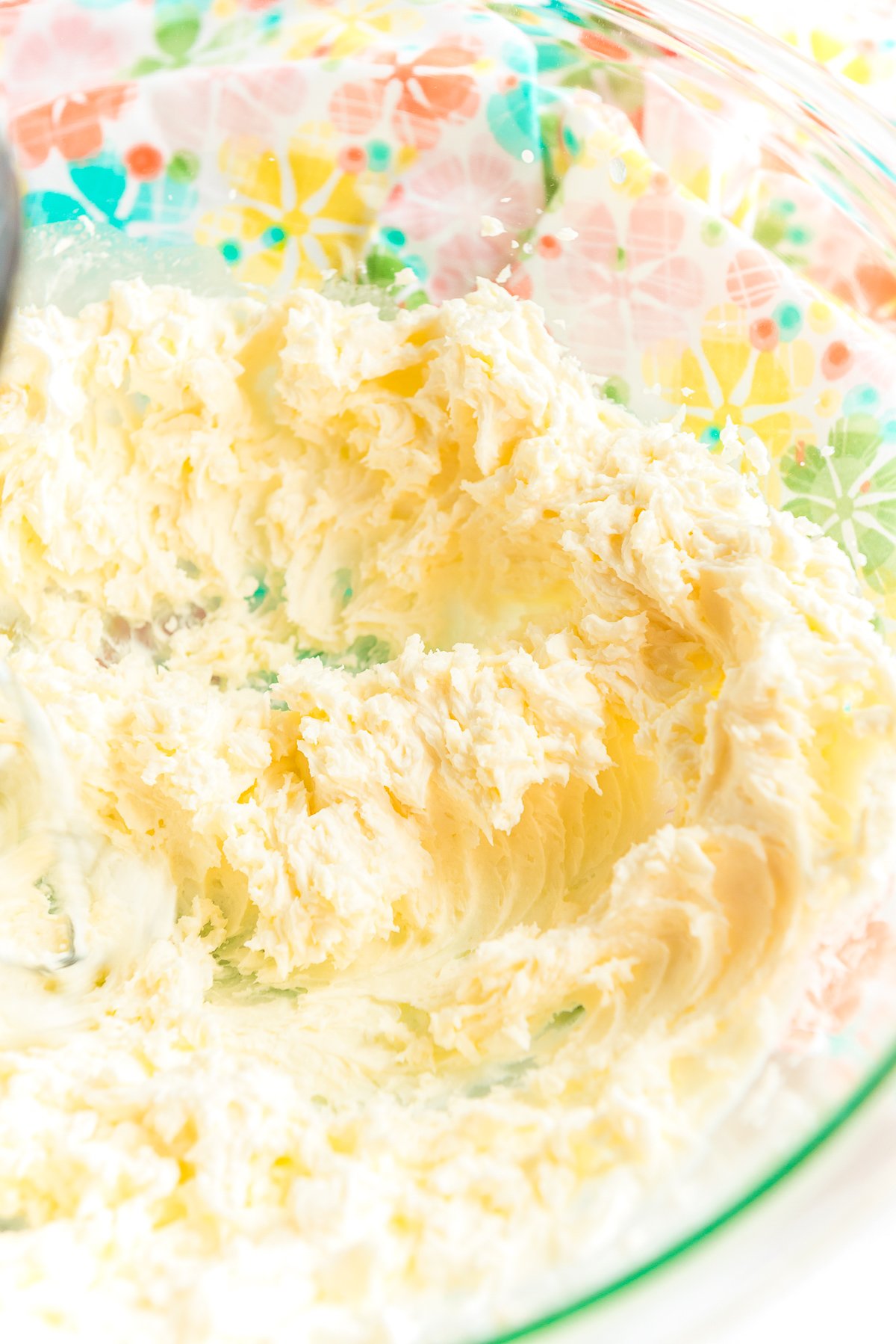 Mascarpone cheese, sugar, and vanilla has been whipped together in a glass mixing bowl.