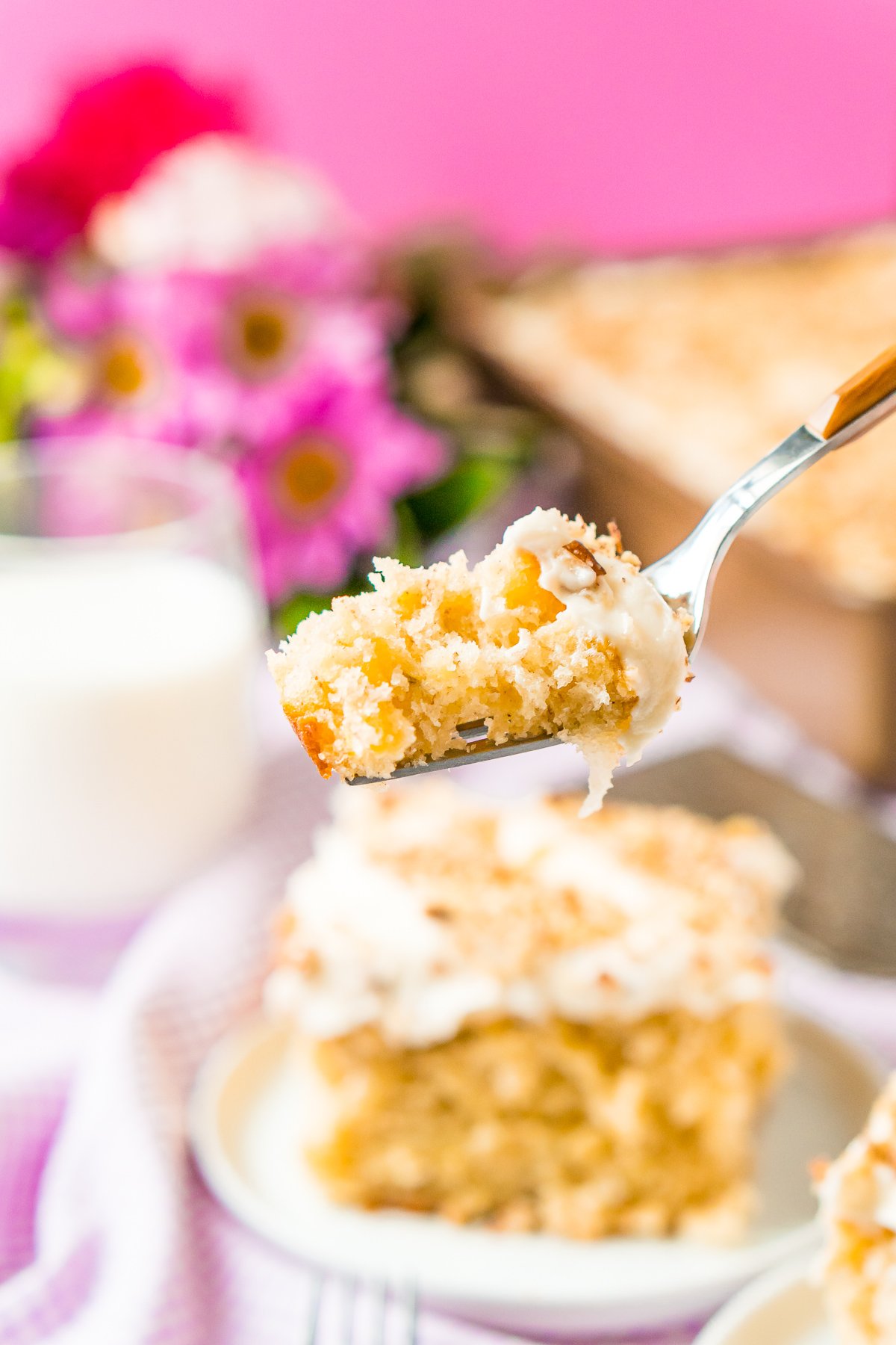 Close up photo of a fork with a bite of hummingbird cake on it.